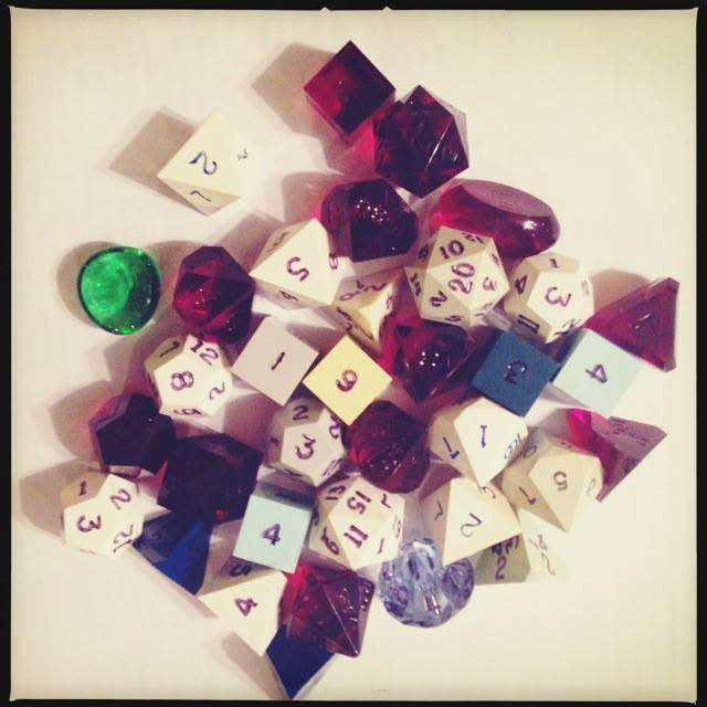 Colourful polyhedral dice clustered on a pale background